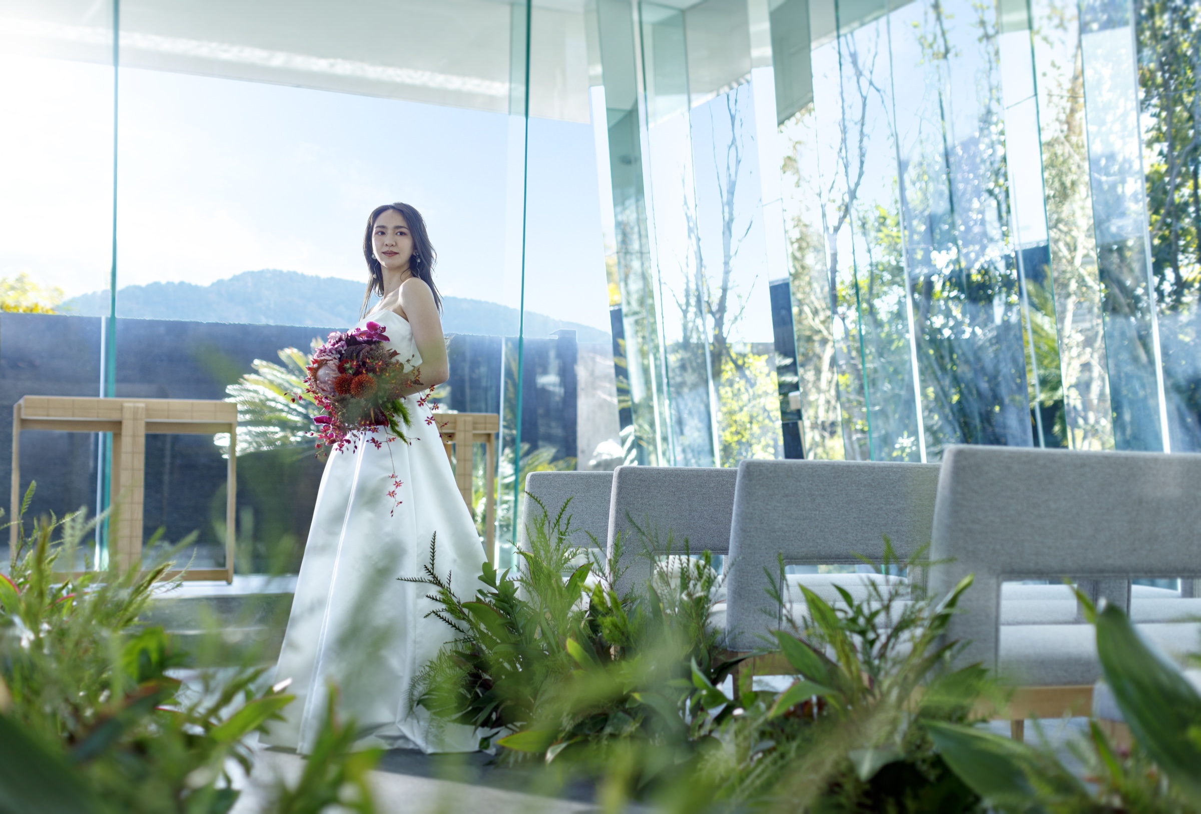 山並みを望むクリスタルチャペルに佇むドレス姿の花嫁｜ザ・オランジェガーデン五十鈴川（三重県伊勢市の結婚式場）